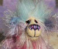 Pru has beautiful, hand painted eyes with eyelids, a splendid nose embroidered with individual threads to compliment her colouring and she has a sweet, friendly smile. Pru's face is a very long and wispy cream mohair with subtle lilac tipping, the fronts of her ears are a sparse, twirly mohair hand dyed blue and on top of her head she has a mop of very dense and soft sky blue faux fur
