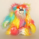 Barbarella is a flamboyant, fun-loving and comical, one of a kind, artist bear by Barbara-Ann Bears in luxurious mohair and rather wild lime faux fur, he stands 12 inches/30 cm tall Barbarella is made from a long and fluffy faux fur which has a white base overlaid with bright yellow, pink, blue and orange. The back of her head, the backs of her ears and the underside of her tail are made from a long rainbow faux fur and her face is as a long white fluffy mohair. Barbarella has hand dyed velvet paw pads. 