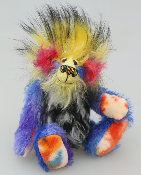 Befuddled is a wildly colourful and very happy, a one of a kind, mohair and faux fur 7 inch tall artist bear by Barbara-Ann Bears. He's in blue mohair with a pale yellow face red ears, a black and white tummy and long black tipped yellow faux fur hair