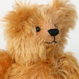 Close-up of Buddy's face, a sweet antique gold teddy bear on a white background