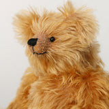 Close-up of a Buddy's face, a sweet antique gold teddy bear on a white background