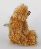Buddy in profile, a sweet antique gold teddy bear on a white background