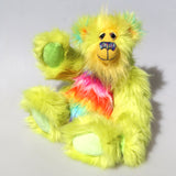 Budgie sitting and waving, Budgie is a 14 inch, fun-loving and comical, one of a kind, artist bear by Barbara-Ann Bears in luxurious mohair and rather wild lime and rainbow faux fur