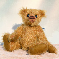 Bunbeary sitting. Bunbeary is a well proportioned yet slightly raggedy traditional teddy bear. Bunbeary is made from beautiful distressed antique gold German mohair which has a warm tan backing, with wool felt paw pads, boot button eyes and a sweet smile.