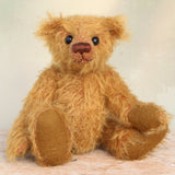 Bunbeary sitting. Bunbeary is a well proportioned yet slightly raggedy traditional teddy bear. Bunbeary is made from beautiful distressed antique gold German mohair which has a warm tan backing, with wool felt paw pads, boot button eyes and a sweet smile.