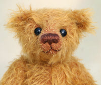 Bunbeary's face. Bunbeary is a well proportioned yet slightly raggedy traditional teddy bear. Bunbeary is made from beautiful distressed antique gold German mohair which has a warm tan backing, with wool felt paw pads, boot button eyes and a sweet smile.