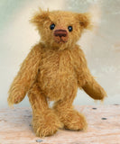 Bunbeary standing. Bunbeary is a well proportioned yet slightly raggedy traditional teddy bear. Bunbeary is made from beautiful distressed antique gold German mohair which has a warm tan backing, with wool felt paw pads, boot button eyes and a sweet smile.