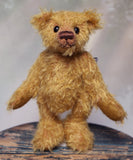 Bunbeary standing. Bunbeary is a well proportioned yet slightly raggedy traditional teddy bear. Bunbeary is made from beautiful distressed antique gold German mohair which has a warm tan backing, with wool felt paw pads, boot button eyes and a sweet smile.