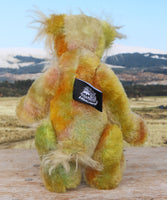 Cardamon standing, viewed from behind. 
Cardamon is a gentle, happy teddy bear, a beautifully coloured one of a kind, hand dyed mohair artist bear by Barbara-Ann Bears
Cardamon stands 9.5 inches/24 cm tall cm tall 