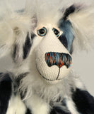A close up of Charleston's face, showing his beautiful long white fluffy mohair, his large hand painted glass eyes, his multi-coloured nose and sweet smile