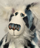 A close up of Charleston's face, showing his beautiful long white fluffy mohair, his large hand painted glass eyes, his multi-coloured nose and sweet smile