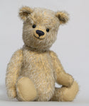 Christopher is a sweet and cuddly, traditional artist teddy bear made in splendid German mohair by Barbara Ann Bears, he stands 14 inches/ 36cm tall and is 11 inches/28cm sitting. Christopher is made from a silvery grey straight pile German mohair, with beige wool felt paw pads vintage boot buttons for eyes and a sweet smile