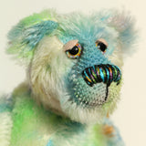 Close-up of Colin Cockles a colourful hand dyed mohair teddy bear on a light background