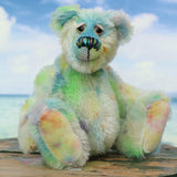 Colin Cockles a colourful hand dyed mohair teddy bear sitting on a wooden surface