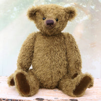brownish-green teddy bear sitting on a wooden surface with a soft, blurred background