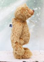 Brown teddy bear standing on a wooden surface with a blurred background