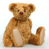 Cuthbert, a one of a kind antique gold teddy bear sitting on a white background
