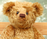 Close-up of a Cuthbert, a one of a kind antique gold teddy bear with a blurred background