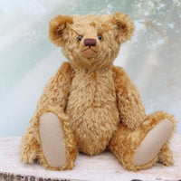 Brown teddy bear sitting on a wooden surface with a light background