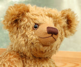 Close-up of a Cuthbert, a one of a kind antique gold teddy bear with a blurred background