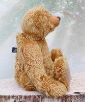 Teddy bear sitting on a ledge with a blurred background