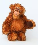 Denzel, a happy brown tipped ginger mohair artist bear by Barbara A Bears, photographed standing against a plain light grey background.