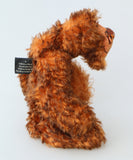 Denzel, a happy brown tipped ginger mohair artist bear by Barbara A Bears, photographed standing side on against a plain light grey background.