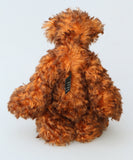 Denzel, a happy brown tipped ginger mohair artist bear by Barbara A Bears, photographed viewed from the back standing against a plain light grey background.