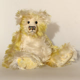 Dorothy teddy bear, a yellow and white hand dyed mohair teddy bear with a multicoloured nose against a white background