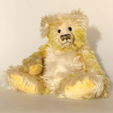 Dorothy teddy bear, a yellow and white hand dyed mohair teddy bear with a multicoloured nose against a white background