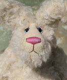 A close-up of Errol's face showing the flecks of colour in his nose and eyes. Errol is a one of a kind mohair rabbit.
Errol stands about 16.5 inches/42cm tall, roughly rabbit-sized, he is made from very long almost white mohair, with matching paw pads, hand painted blue eyes, a carefully embroidered nose and a sweet pink tail. 