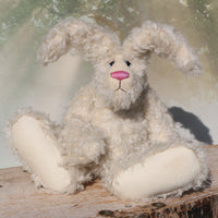Errol sitting. Errol is a one of a kind mohair rabbit.
Errol stands about 16.5 inches/42cm tall, roughly rabbit-sized, he is made from very long almost white mohair, with matching paw pads, hand painted blue eyes, a carefully embroidered nose and a sweet pink tail. 