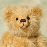 Close-up of Euan, a mohair collector's teddy bear with a soft texture on a light background