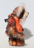 Profile of Flambé by Barbara Ann Bears, a handmade, distressed teddy bear with shaggy brown and orange fur, a cream-coloured stitched face, and colourful striped paw pads