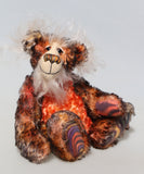 Flambé by Barbara Ann Bears, a handmade, distressed teddy bear with shaggy brown and orange fur, a cream-coloured stitched face, and colourful striped paw pads