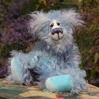 Hyssop is a gentle, happy teddy bear, a beautifully blue one of a kind, hand dyed mohair artist bear by Barbara-Ann Bears, he stands 9 inches/23 cm tall  Hyssop is mainly made from a fairly long, sparse hand dyed sky blue, coupled with a long fluffy white mohair with blue tipping and hand-dyed velvet paw pads.   Hyssop has beautiful hand painted eyes with eyelids, a nose embroidered from individual threads to complement his colouring and he has a huge, friendly smile. 