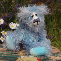 Hyssop is a gentle, happy teddy bear, a beautifully blue one of a kind, hand dyed mohair artist bear by Barbara-Ann Bears, he stands 9 inches/23 cm tall  Hyssop is mainly made from a fairly long, sparse hand dyed sky blue, coupled with a long fluffy white mohair with blue tipping and hand-dyed velvet paw pads.   Hyssop has beautiful hand painted eyes with eyelids, a nose embroidered from individual threads to complement his colouring and he has a huge, friendly smile. 