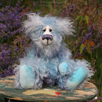 Hyssop is a gentle, happy teddy bear, a beautifully blue one of a kind, hand dyed mohair artist bear by Barbara-Ann Bears, he stands 9 inches/23 cm tall  Hyssop is mainly made from a fairly long, sparse hand dyed sky blue, coupled with a long fluffy white mohair with blue tipping and hand-dyed velvet paw pads.   Hyssop has beautiful hand painted eyes with eyelids, a nose embroidered from individual threads to complement his colouring and he has a huge, friendly smile. 