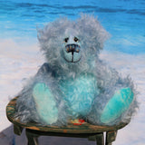 Kieran Cockles is a warm and friendly, one of a kind, artist bear by Barbara-Ann Bears in wonderful fluffy hand-dyed mohair like a blue summer sky, he stands 10 inches/25 cm tall. Kieran Cockles is made from long and fluffy, tousled mohair that Barbara has hand-dyed in a gorgeous sky blue with hand painted glass eyes, a wonderfully embroidered nose and a humongous cheerful smile