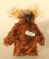 Nimble Nigel standing, view of his back. Nimble Nigel is an endearingly sweet and joyful one of a kind artist bear by Barbara-Ann Bears in wonderful brown mohair, he stands just 6.5 inches/17cm 