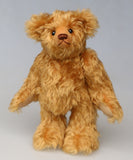 Owen, a traditional antique gold teddy bear on a light grey background