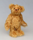 Owen, a traditional antique gold teddy bear on a light grey background
