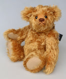 Owen, a traditional antique gold teddy bear on a light grey background