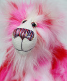 Pamela Pinkerton a colourful teddy bear with pink and white fur and a multicoloured mouth on a white background, close-up of face
