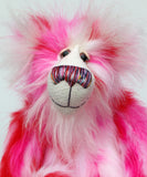 Pamela Pinkerton a colourful teddy bear with pink and white fur and a multicoloured mouth on a white background, close-up of face