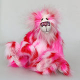 Pamela Pinkerton a colourful teddy bear with pink and white fur and a multicoloured mouth on a white background