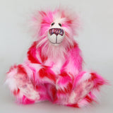 Pamela Pinkerton a colourful teddy bear with pink and white fur and a multicoloured mouth on a white background