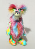 Plinkety Plonk by Barbara Ann Bears standing up. He's a wildly colourful bear in printed fabric, long fluffy mohair and very long multi coloured faux fur.