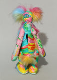 Plinkety Plonk by Barbara Ann Bears showing a view of his back standing up. He's a wildly colourful bear in printed fabric, long fluffy mohair and very long multi coloured faux fur.