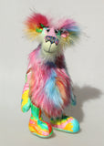 Plinkety Plonk by Barbara Ann Bears standing up. He's a wildly colourful bear in printed fabric, long fluffy mohair and very long multi coloured faux fur.